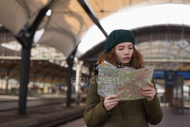 Bella donna alla ricerca della mappa nella stazione ferroviaria — Foto stock