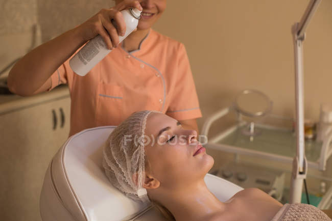 Esthéticienne donnant un traitement de beauté à une cliente dans un salon — Photo de stock