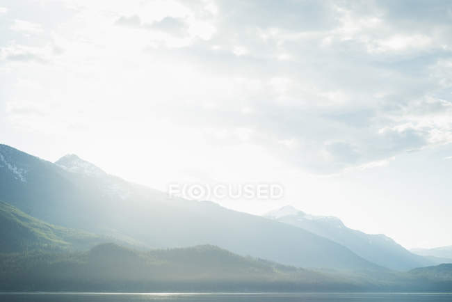 В горах с белыми тучами в солнечный день — стоковое фото