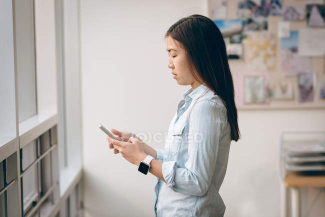 Ejecutiva femenina usando teléfono móvil en la oficina - foto de stock