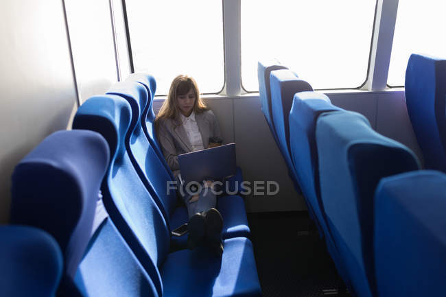 Beautiful woman using laptop in cruise ship — Stock Photo