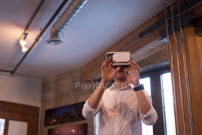 Executivo masculino usando fone de ouvido de realidade virtual no escritório — Fotografia de Stock