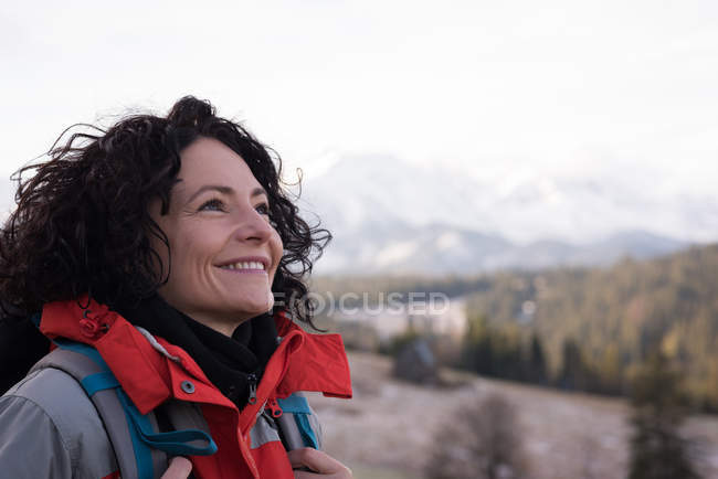 Mulher feliz de pé com mochila durante o inverno — Fotografia de Stock