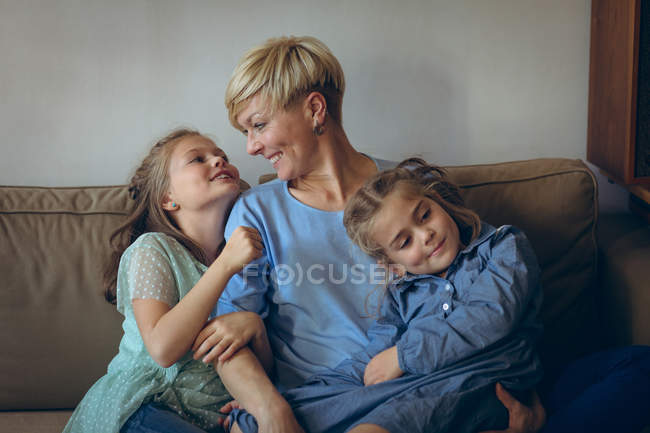 Madre e figlie si rilassano sul divano in soggiorno — Foto stock