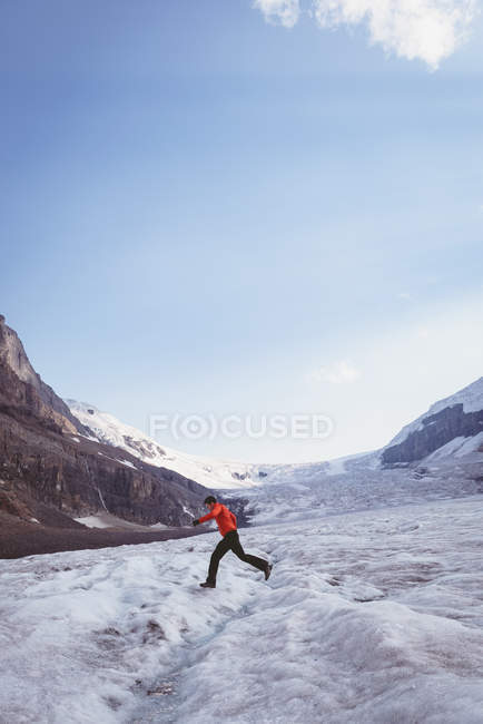 Mann läuft im Winter durch eine Schneelandschaft — Stockfoto