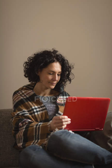 Woman suing laptop in living room at home — Stock Photo
