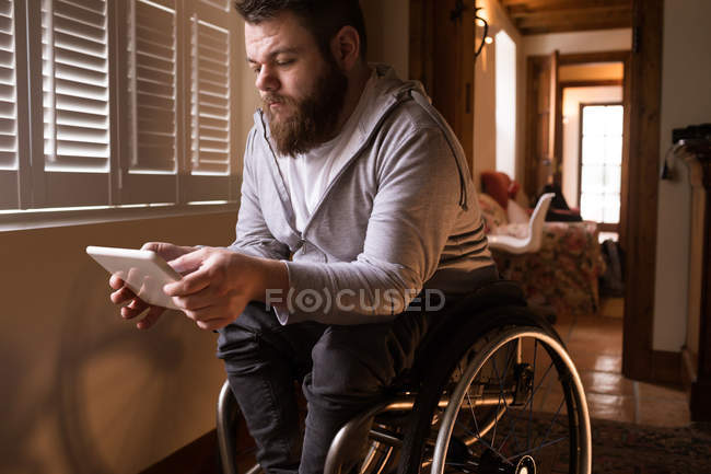 Hombre discapacitado usando tableta digital en casa - foto de stock