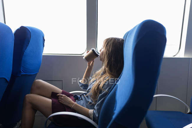 Thoughtful woman drinking coffee in cruise ship — Stock Photo