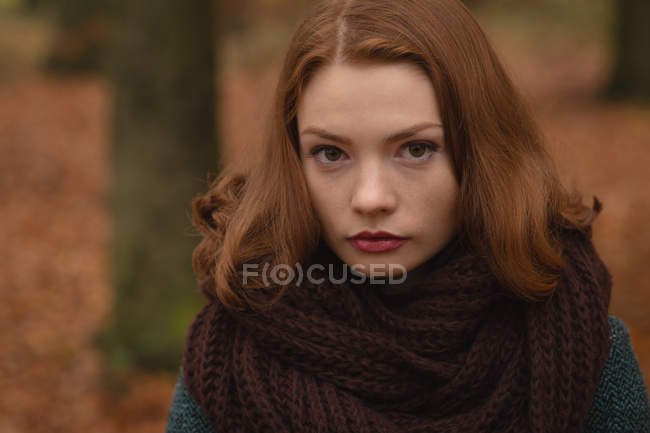 Портрет женщины, стоящей в парке осенью — стоковое фото