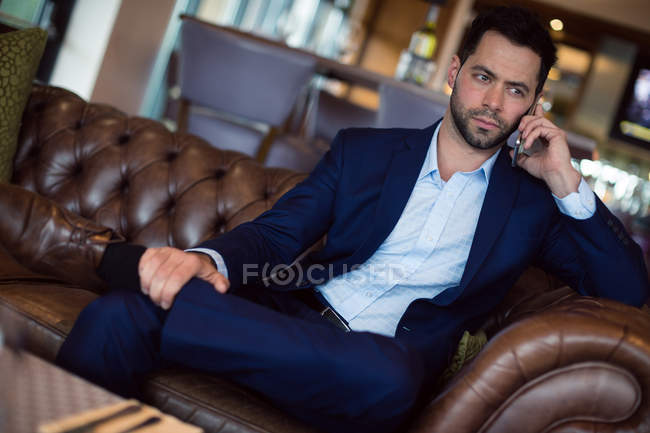 Businessman talking on mobile phone in hotel — Stock Photo