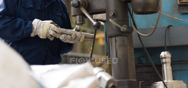 Mid section of technician cutting metal in metal industry — Stock Photo