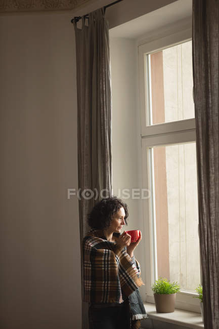 Nachdenkliche Frau beim Kaffee im heimischen Wohnzimmer — Stockfoto