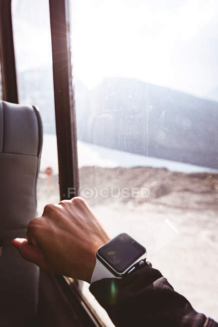 Mujer comprobando el tiempo en su smartwatch en un día soleado - foto de stock