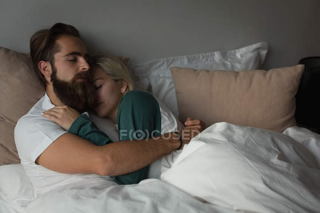 Couple s'embrassant dans la chambre à coucher à la maison — Photo de stock
