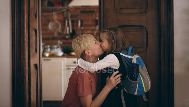 Liebevolle Tochter küsst ihre Mutter zu Hause — Stockfoto