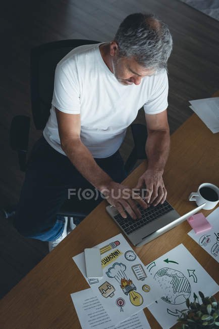Businessman working on laptop at desk in office — Stock Photo