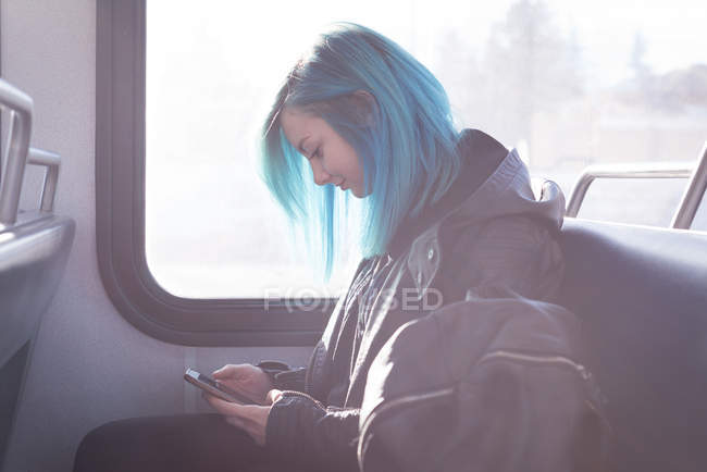 Stylish woman using mobile phone while travelling in train — Stock Photo