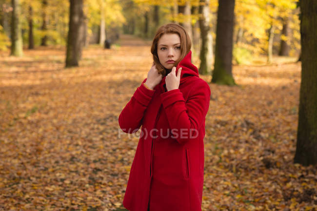 Mujer pensativa de pie en el parque - foto de stock