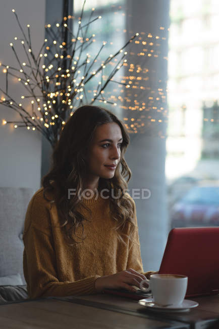 Jovem mulher usando laptop no restaurante — Fotografia de Stock