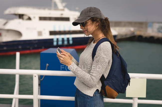 Красива жінка використовує мобільний телефон на круїзному кораблі — стокове фото