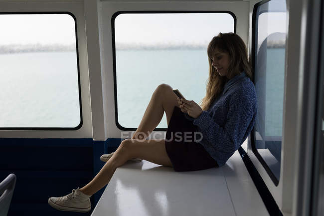 Красива жінка використовує мобільний телефон у круїзному кораблі — стокове фото