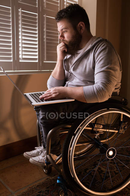 Використання ноутбука на дому інвалідів юнак — стокове фото