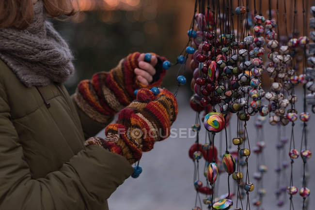 Mid section of woman in winter clothing holding christmas decoration — Stock Photo