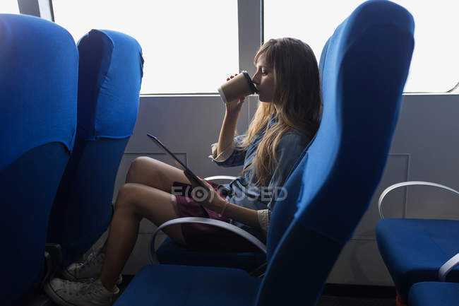 Schöne Frau mit digitalem Tablet beim Kaffee im Kreuzfahrtschiff — Stockfoto
