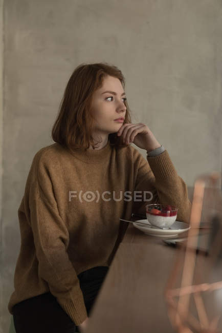 Удумлива жінка з десертом у кафе — стокове фото
