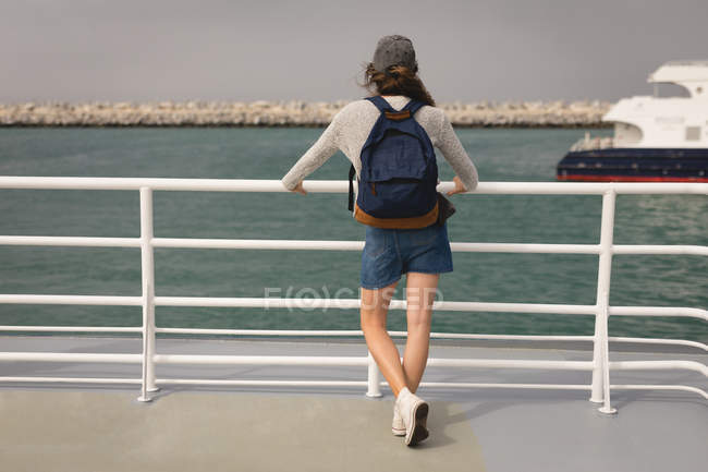 Vue arrière de la femme avec sac à dos debout sur un bateau de croisière — Photo de stock
