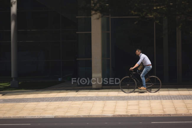 Homme à vélo sur le trottoir en ville — Photo de stock