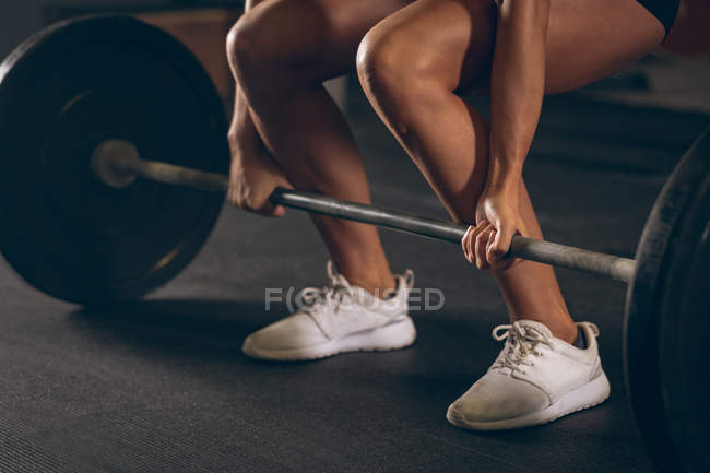 Nahaufnahme einer fitten Frau beim Anheben der Langhantel im Fitnessstudio — Stockfoto