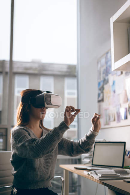 Ejecutivo usando auriculares de realidad virtual en la oficina - foto de stock