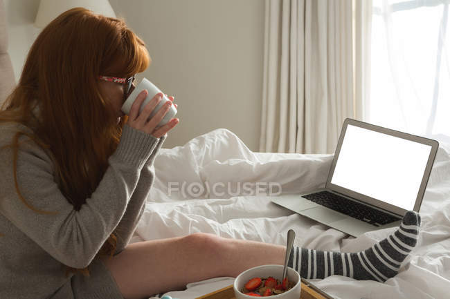 Frau mit schwarzem Kaffee im Schlafzimmer zu Hause — Stockfoto