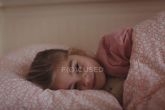 Bambina che dorme sul letto in camera da letto a casa — Foto stock