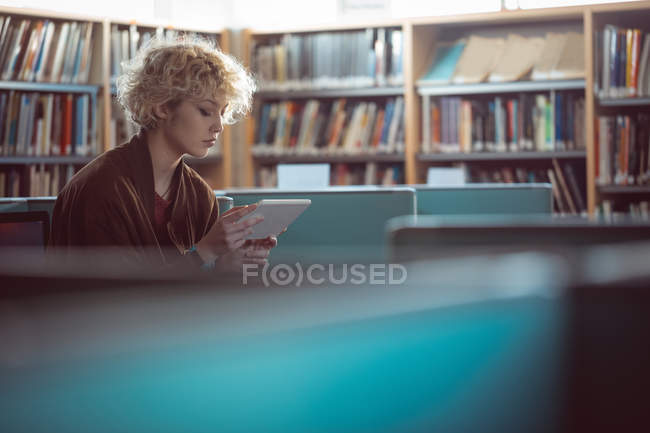 Junge Frau nutzt digitales Tablet in Bibliothek — Stockfoto