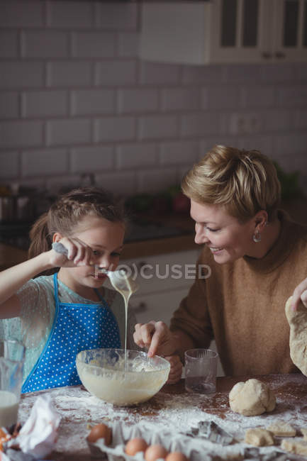 Мать и дочь готовят кексы на кухне дома — стоковое фото
