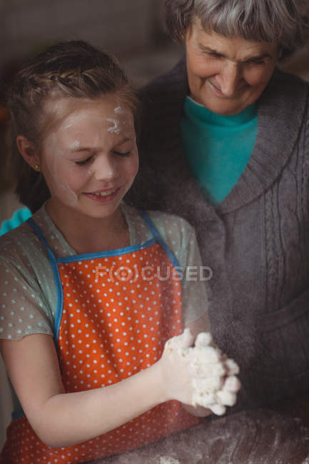 Grandmother and granddaughter preparing cupcake in kitchen at home — Stock Photo