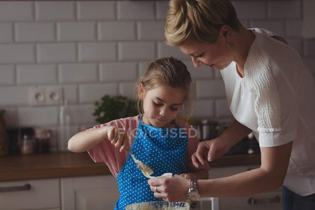 Мать и дочь готовят кексы на кухне дома — стоковое фото