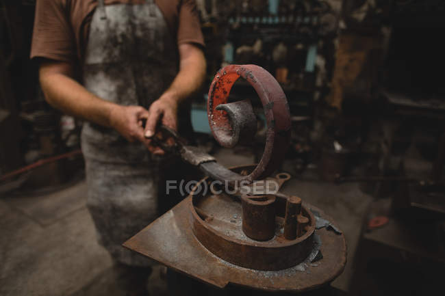 Schmied formt Metallstange in Werkstatt — Stockfoto
