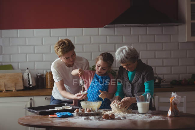 Famiglia multi-generazione che prepara cupcake in cucina a casa — Foto stock