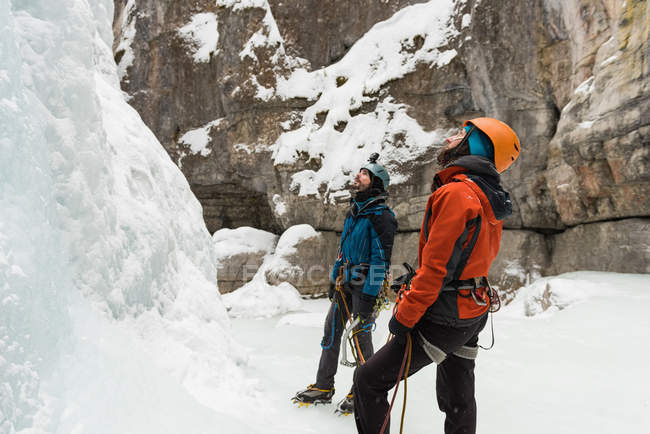 Couple standing together near rocky mountain during winter — Stock Photo