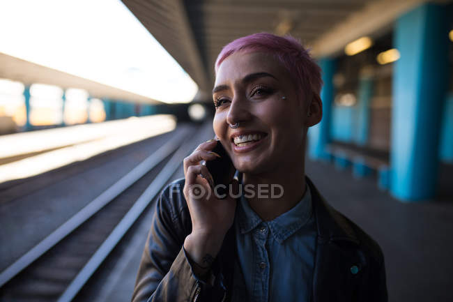 Mujer elegante hablando en el teléfono móvil en la estación de tren - foto de stock