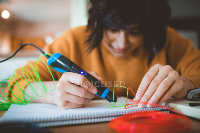 Mujer dibujando un boceto en un libro en casa - foto de stock