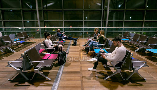 Commuters esperando na área de espera no aeroporto — Fotografia de Stock