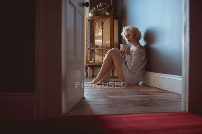 Young woman having coffee at home — Stock Photo