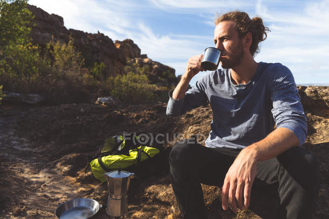 Male hiker having coffee in countryside on a sunny day — Stock Photo