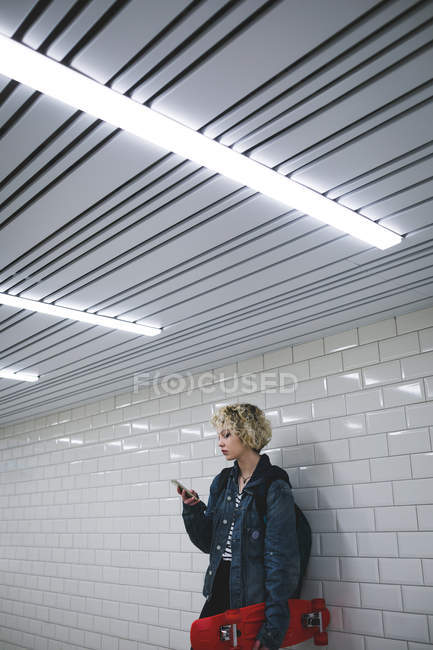 Junge Frau benutzt Handy in U-Bahn — Stockfoto