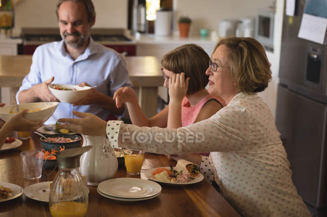 Familia almorzando en la cocina en casa - foto de stock