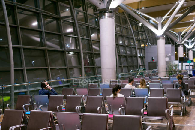 Commuters waiting in waiting area at airport — Stock Photo